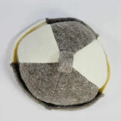 Top view of a handmade felt hat with a geometric patchwork design in gray and off-white, featuring a top loop and folded brim.